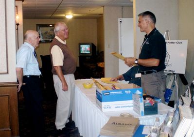 Friday Afternoon Registration
Bill Lindberg, 55, arrives at Registration to receive his packet from Gerry Leggieri, 68.  Carroll Judd, 53, looks on.
